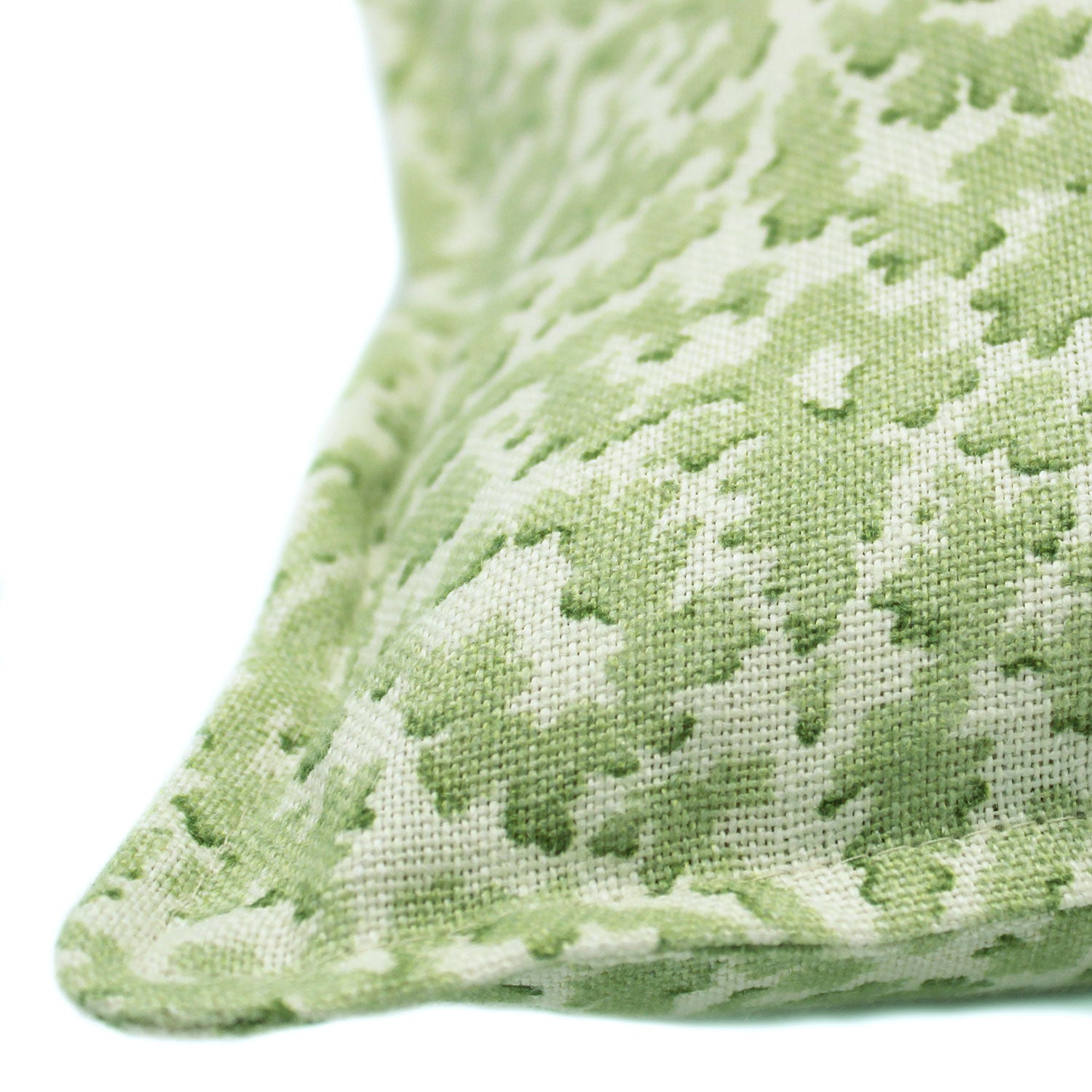 A green and cream linen cushion with a damask pattern.