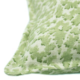 A green and cream linen cushion with a damask pattern.