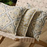 A grey, cream and brown linen cushion with a central motif pattern.