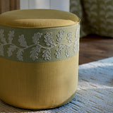 Round ottoman with oakleaf embroidery strip.