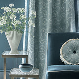 Living room with dark blue sofa, decorative pillows, and embroidered curtains in blue.