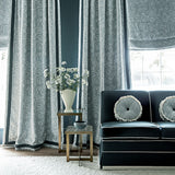 Living room with dark blue sofa, decorative pillows, and embroidered curtains in blue.