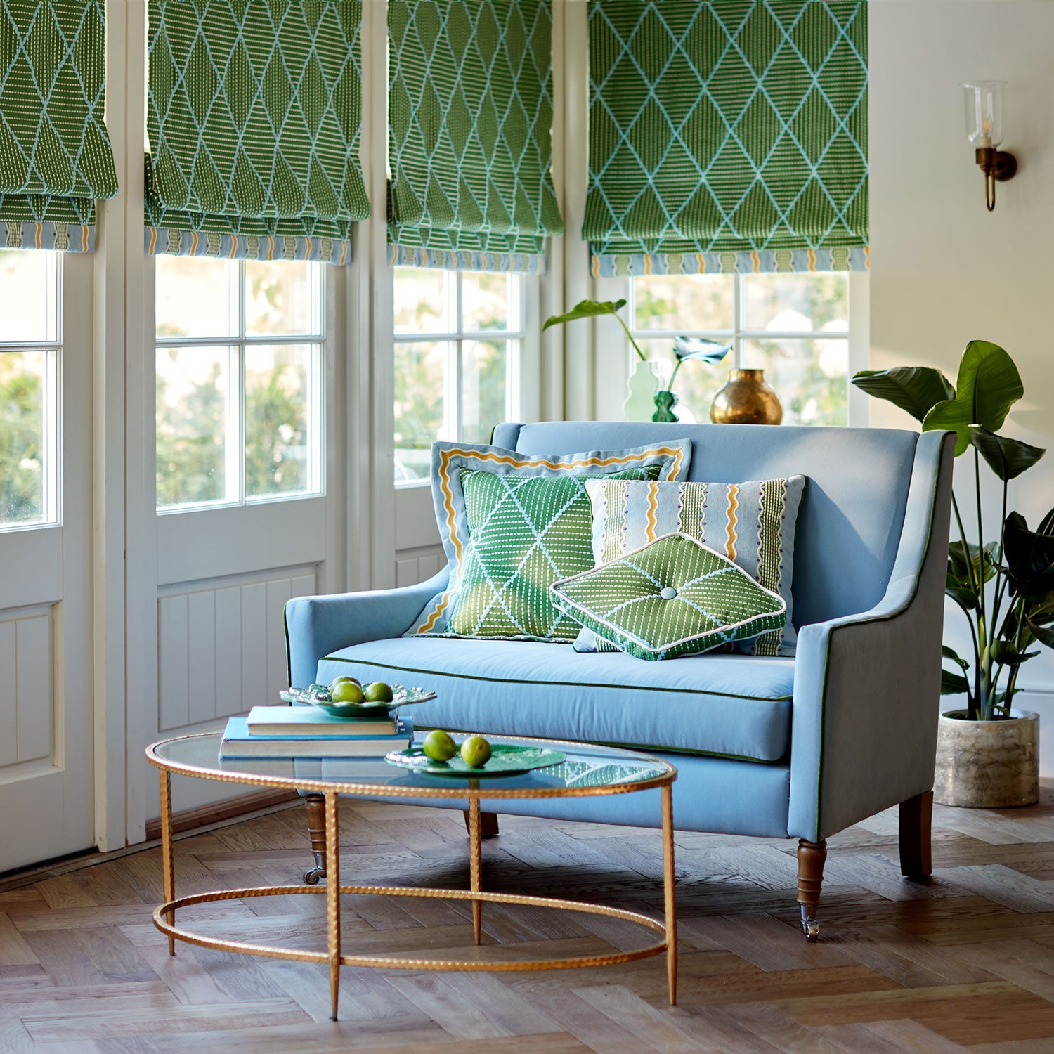 Living room with a blue sofa and geometric embroidery blinds and cushions.