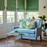 Living room with a blue sofa and geometric embroidery blinds and cushions.