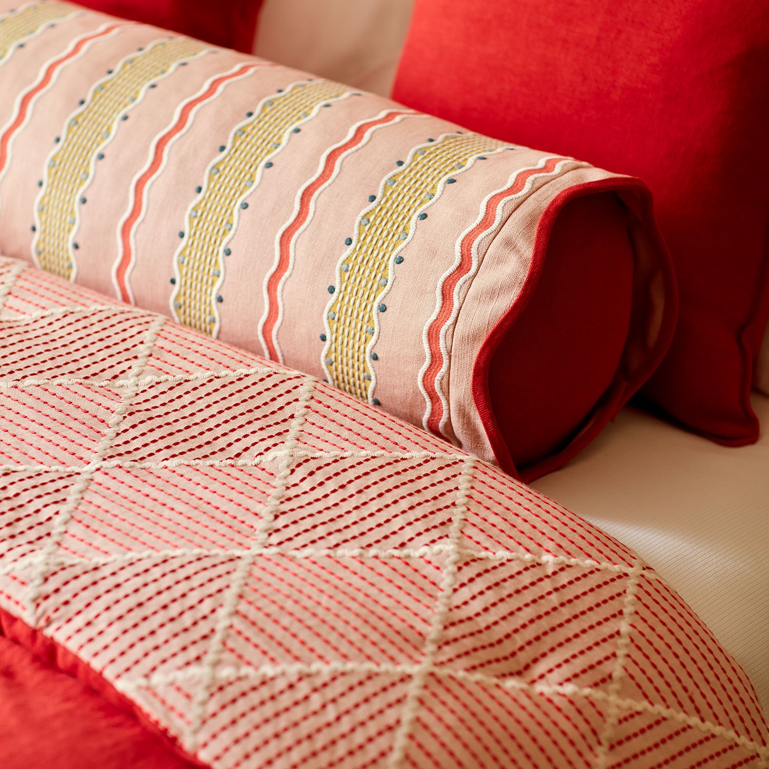 Close-up of a quilt with geometric pattern on a bed.