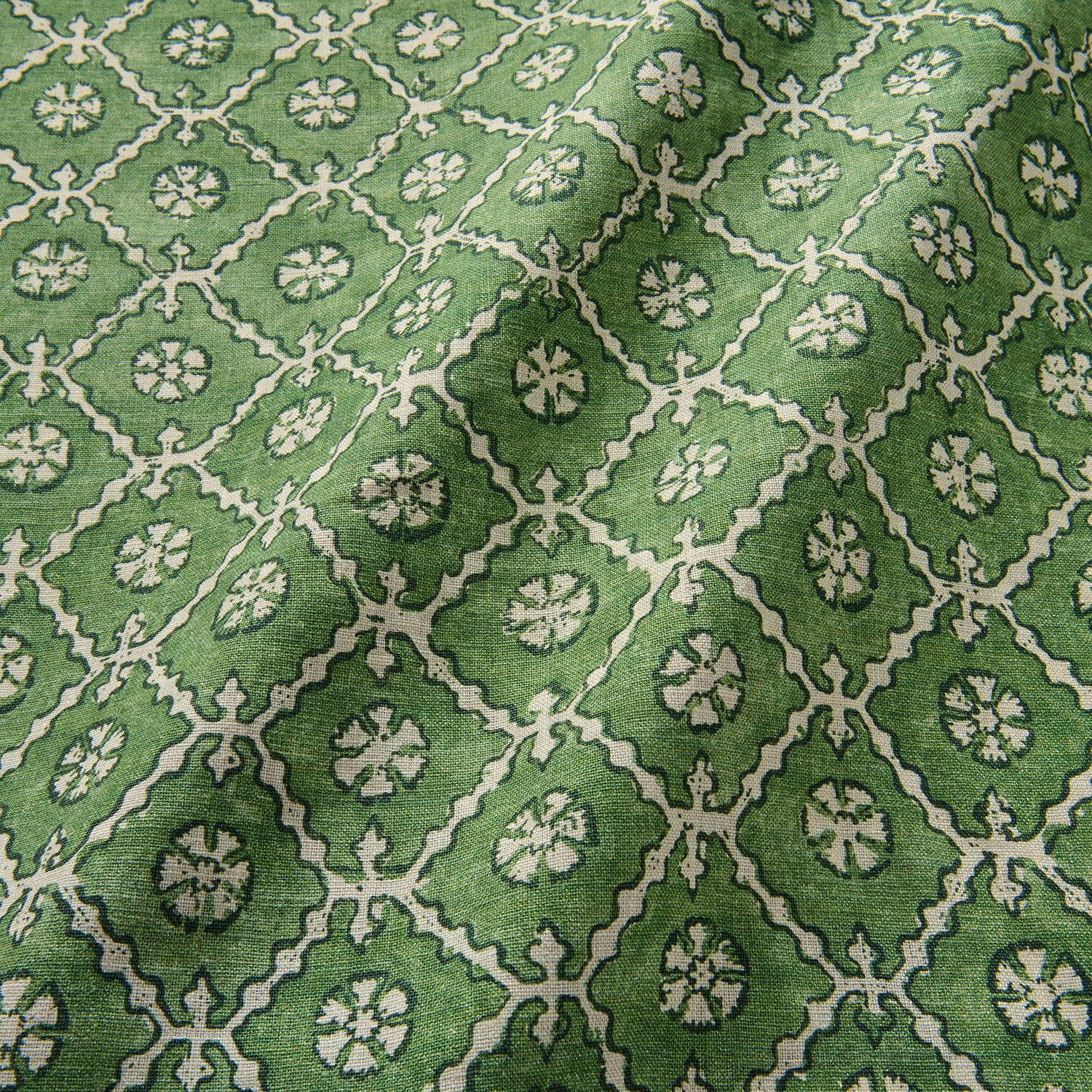 Linen fabric with a hand block-style pattern in green, black and cream