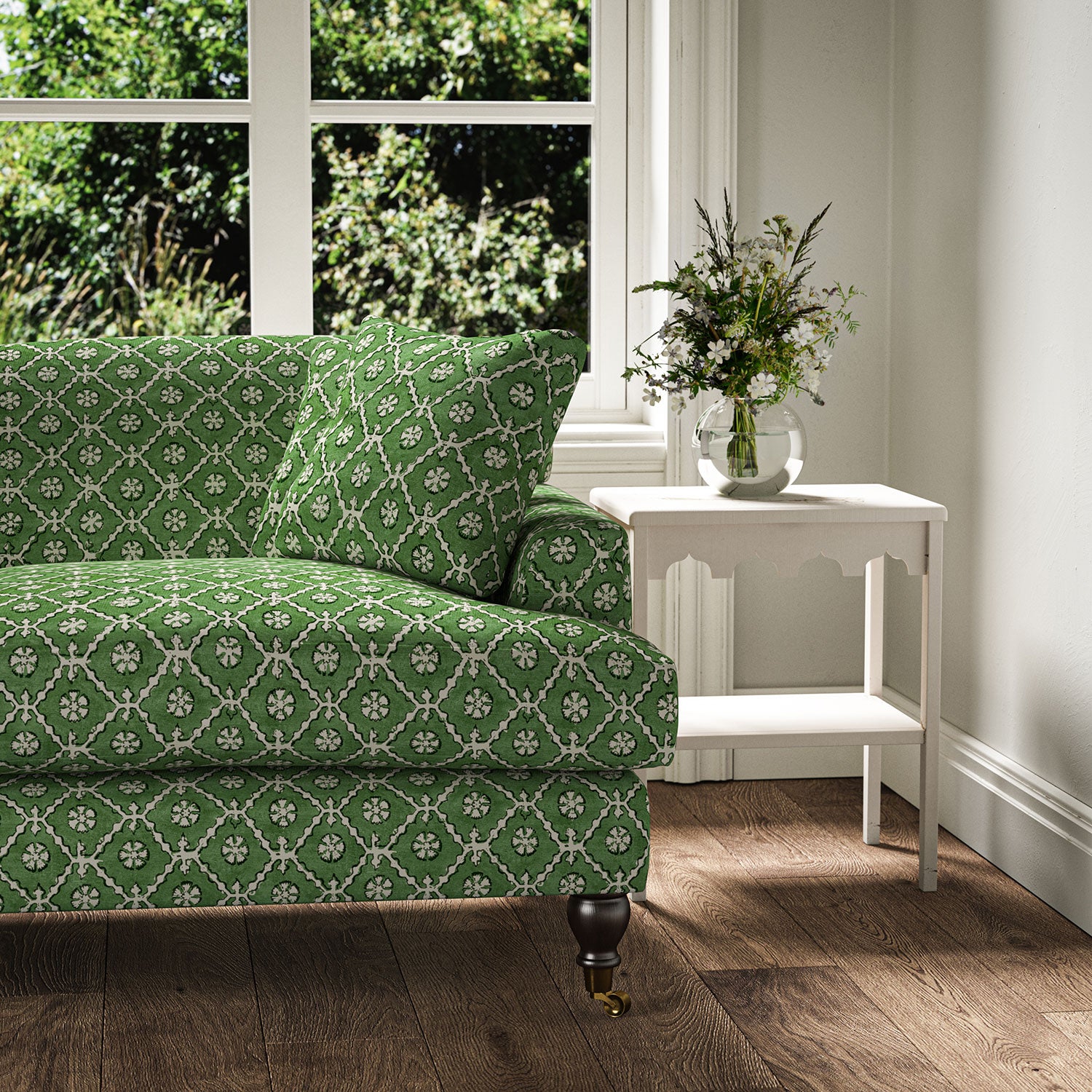Sofa covered in a linen fabric with a hand block-style pattern in green, black and cream
