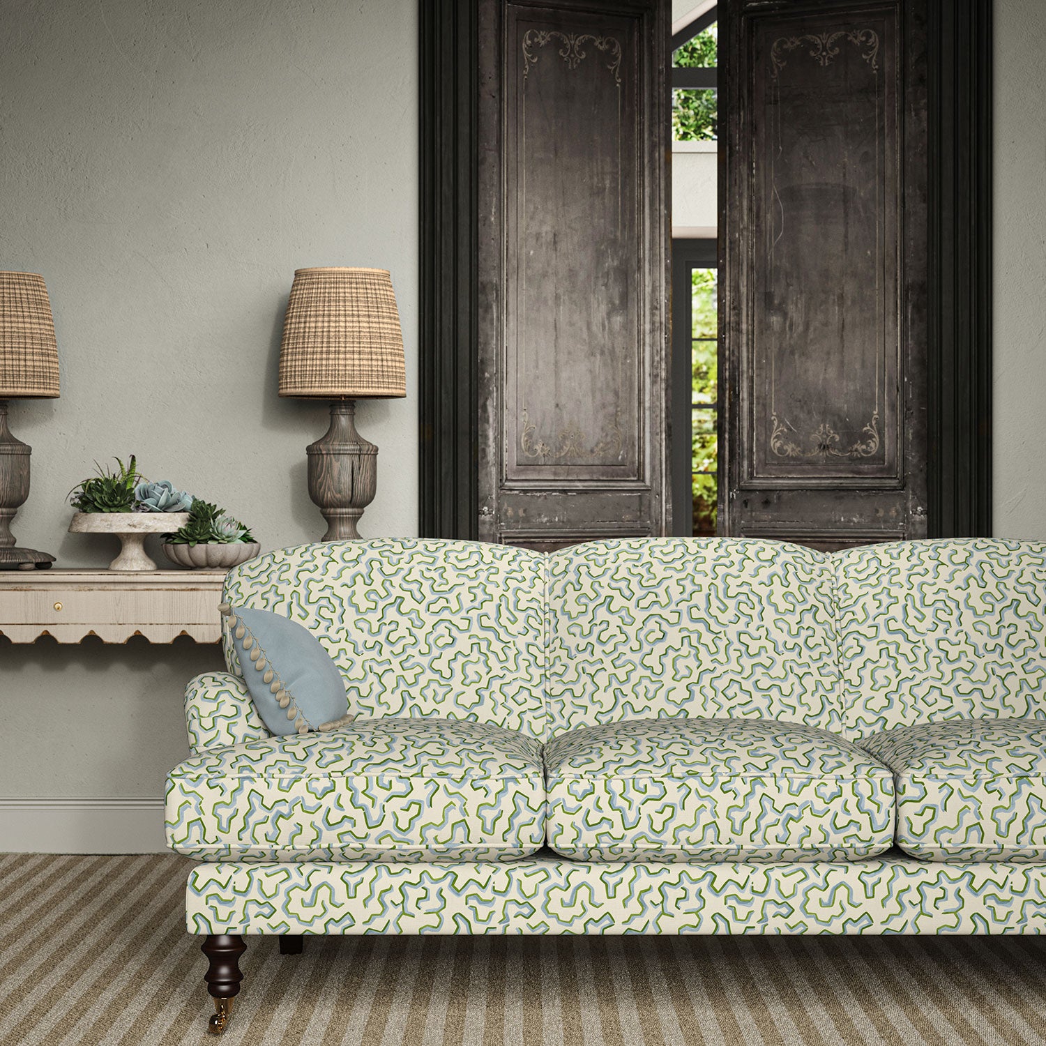 Sofa upholstered in a printed linen fabric in blue, green, and off white featuring a feel of a classic animal print.