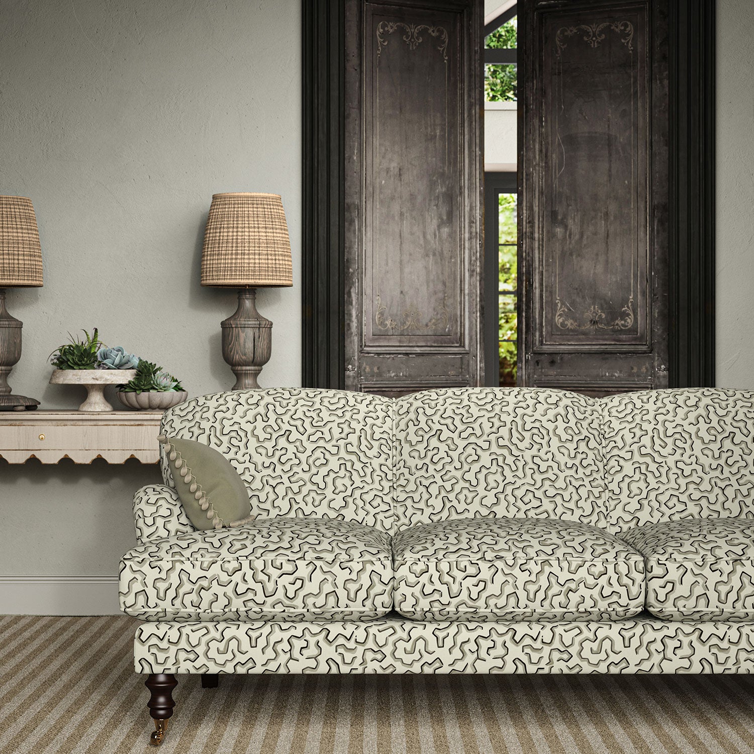 Sofa upholstered in a printed linen fabric in black, grey, and off white featuring a feel of a classic animal print.