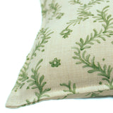 A green and cream linen cushion with a marine-style pattern.