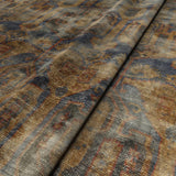 A printed velvet fabric sample in blue, brown and black featuring an opulent pattern.