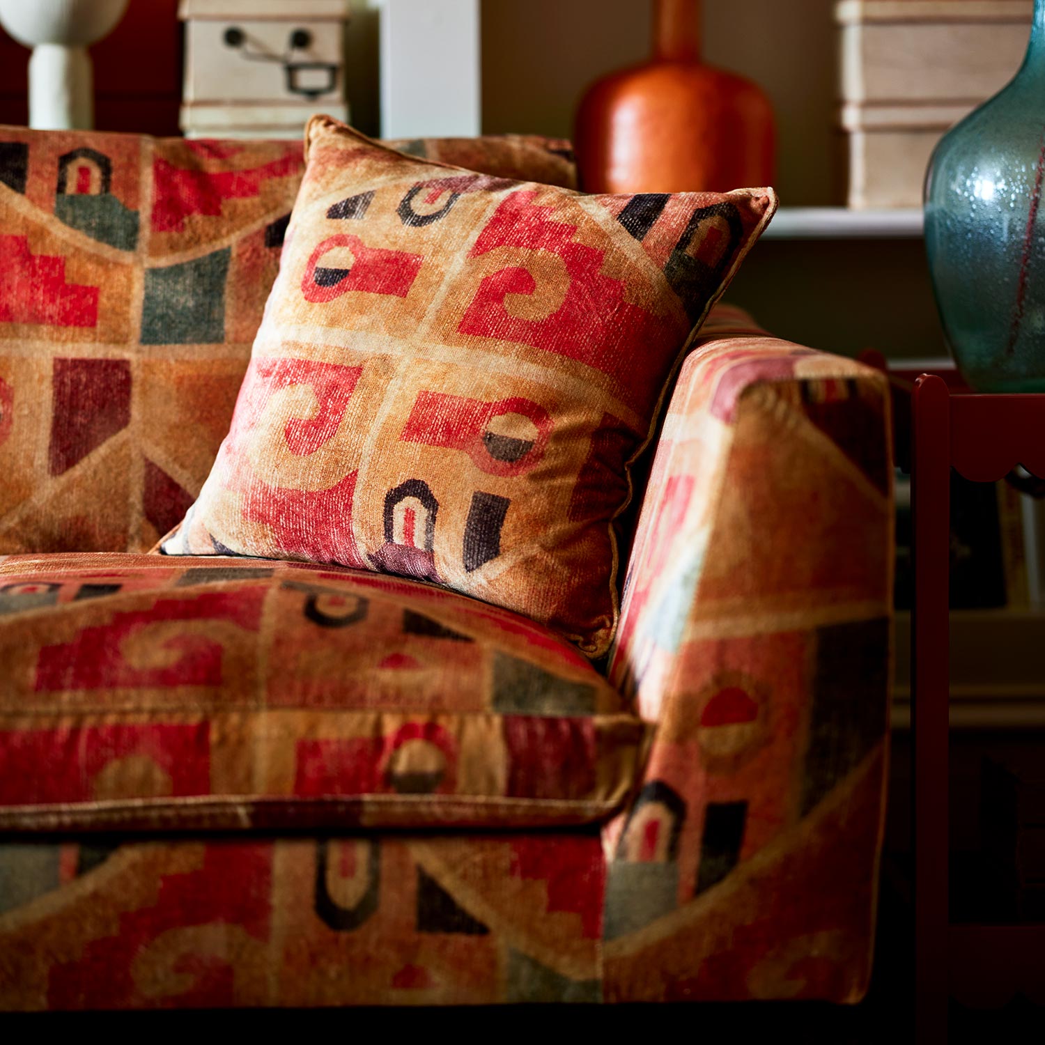 Sofa upholstered in a multicoloured printed velvet fabric featuring an abstract geometric pattern.