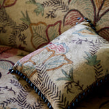 Cushion in a distressed printed velvet fabric with palms in sandy and red tones
