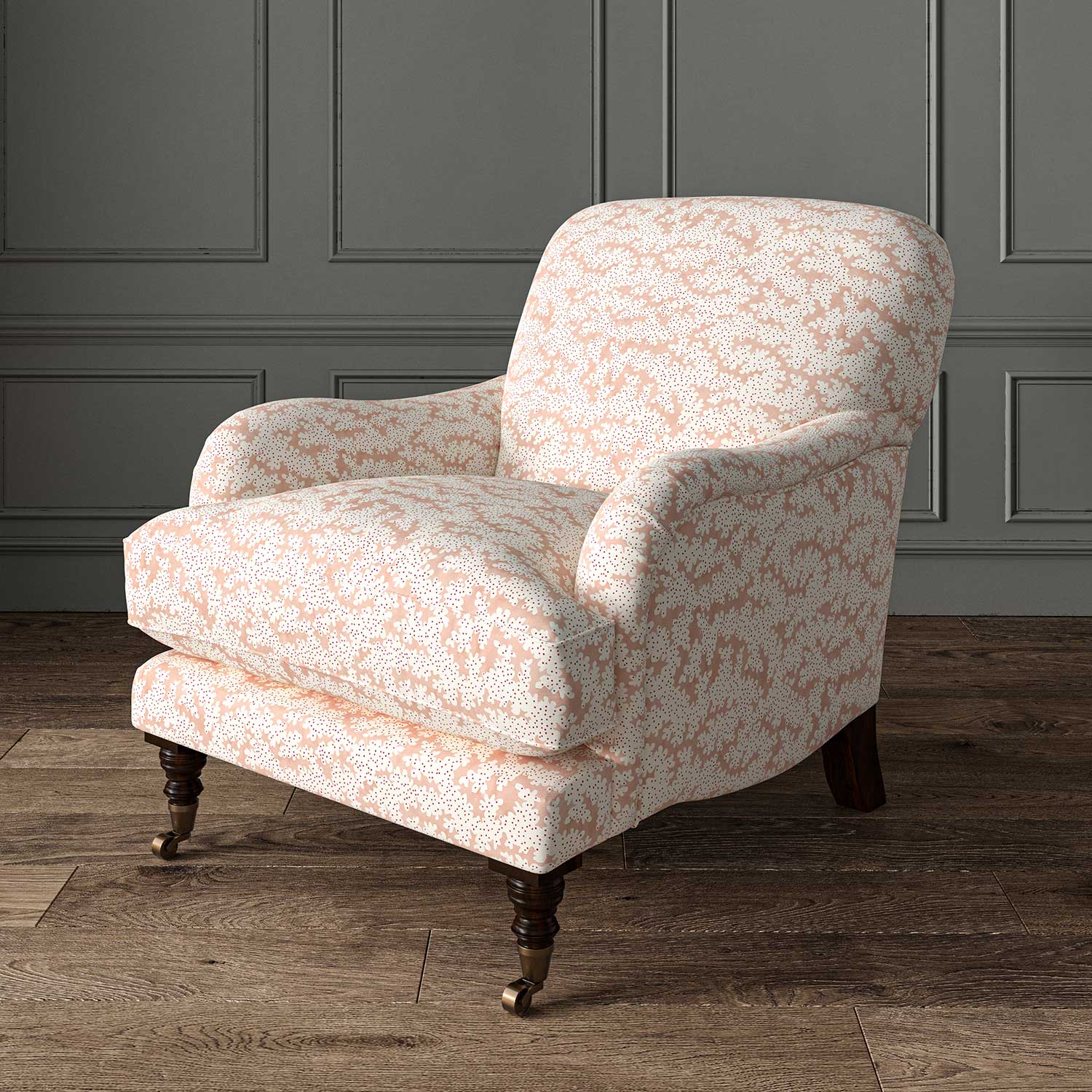 Chair upholstered in a printed linen fabric sample in pink, red and off white featuring a stylized coral pattern.