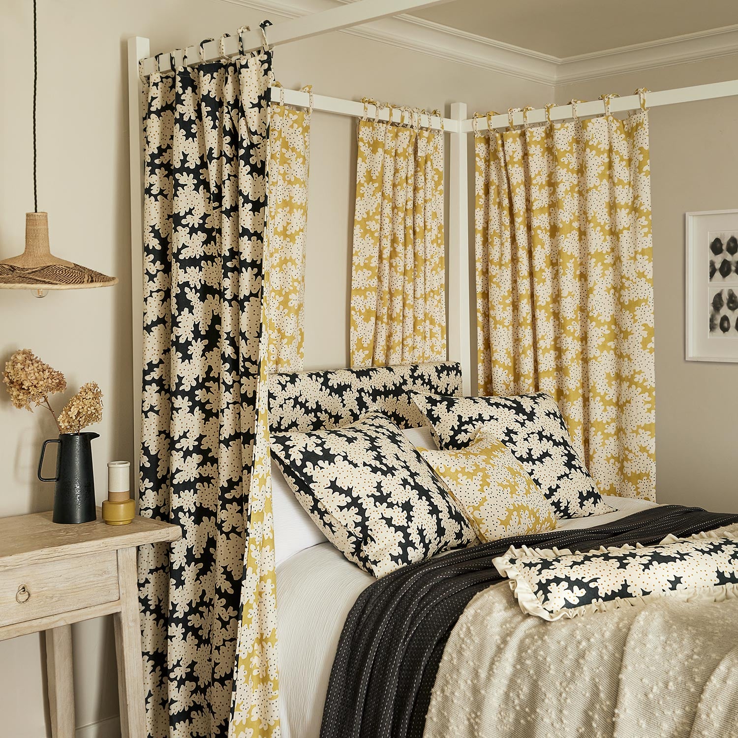 Sofa upholstered in a printed linen fabric sample in black, brown and off white featuring a stylized coral pattern.