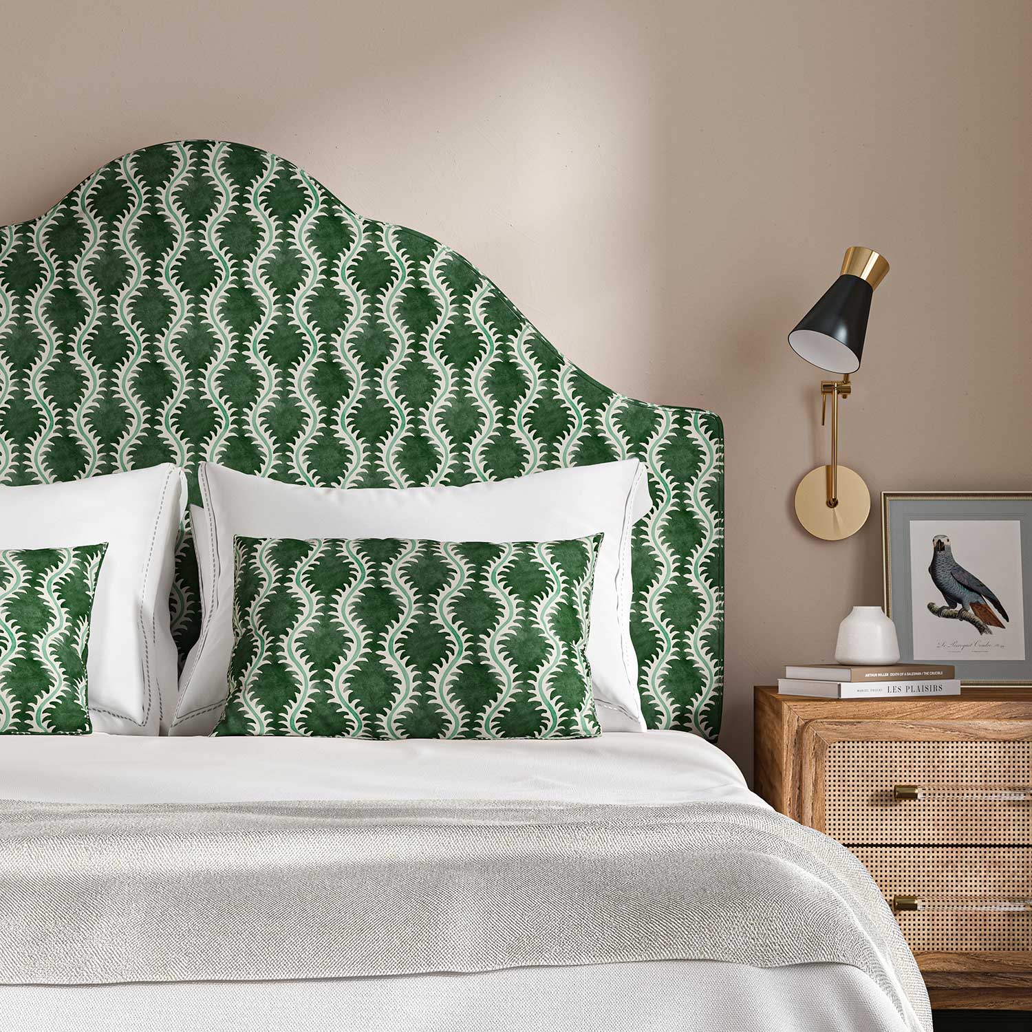 Headboard upholstered in a printed linen fabric sample in green and off white featuring a stylized fern pattern.