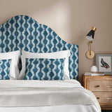 Headboard upholstered in a printed linen fabric in blue and off white featuring a stylized fern pattern.