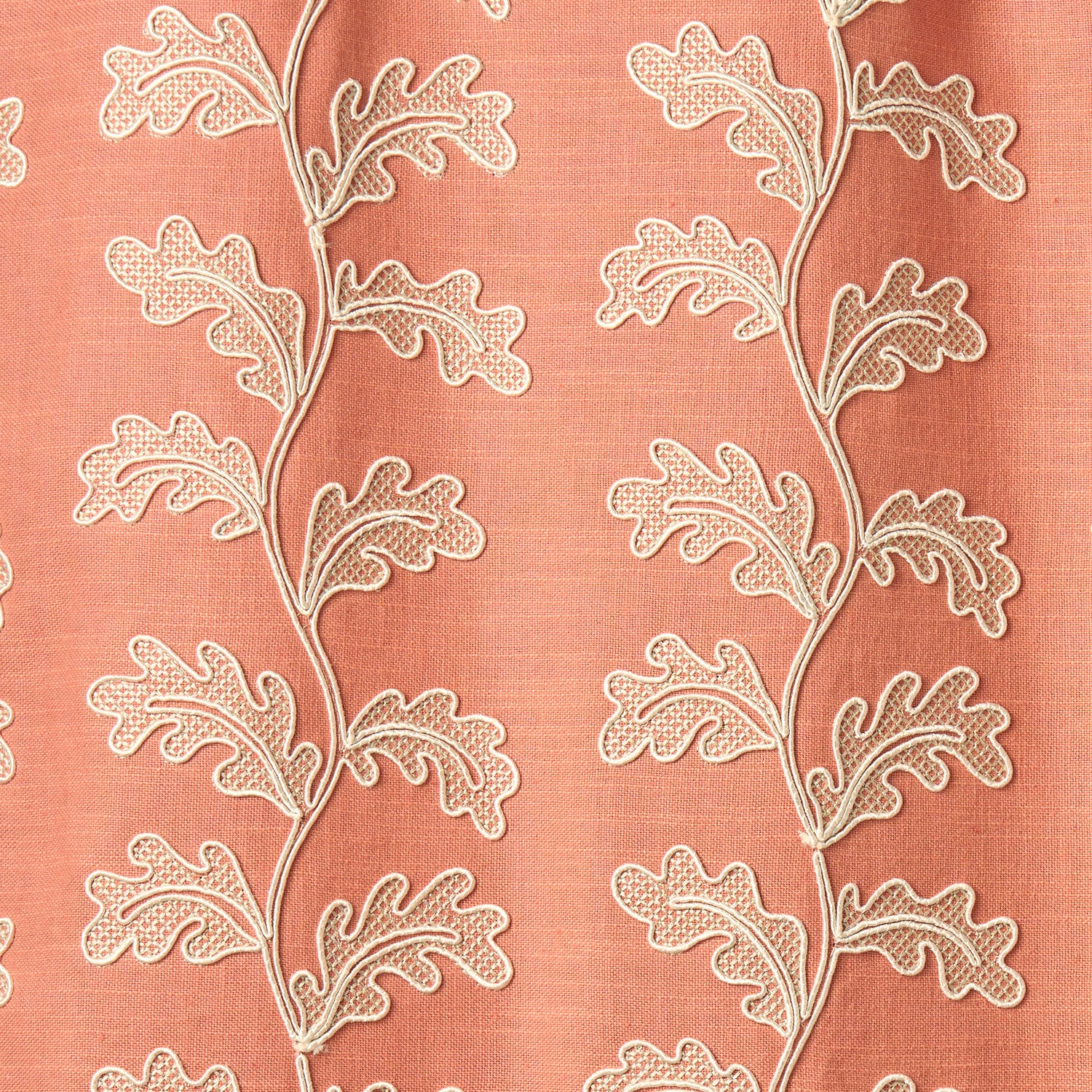 Decorative oakleaf embroidery on a coral background.