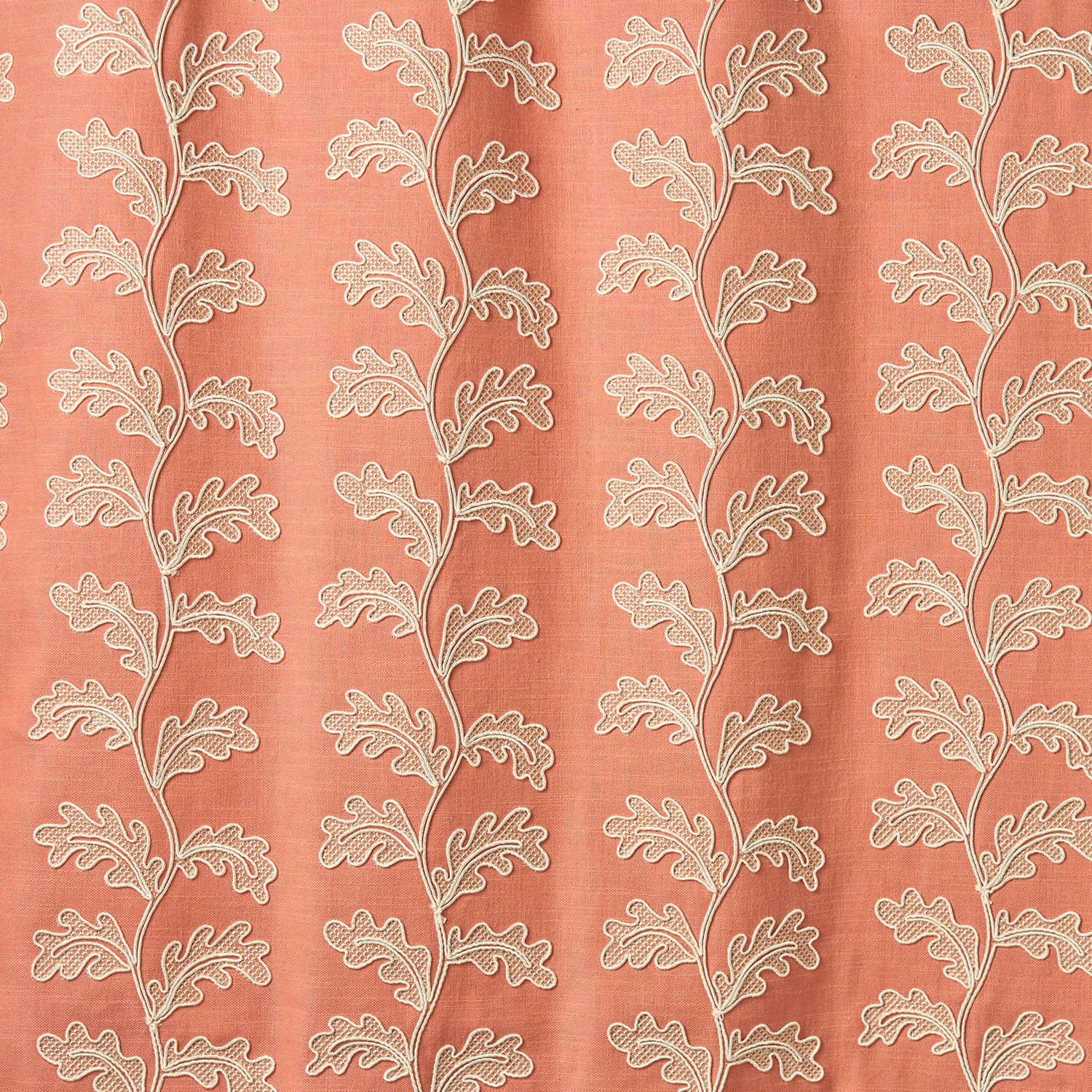 Decorative oakleaf embroidery on a coral background.
