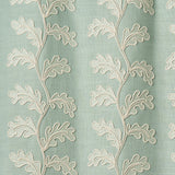 Decorative oakleaf embroidery on a blue background.