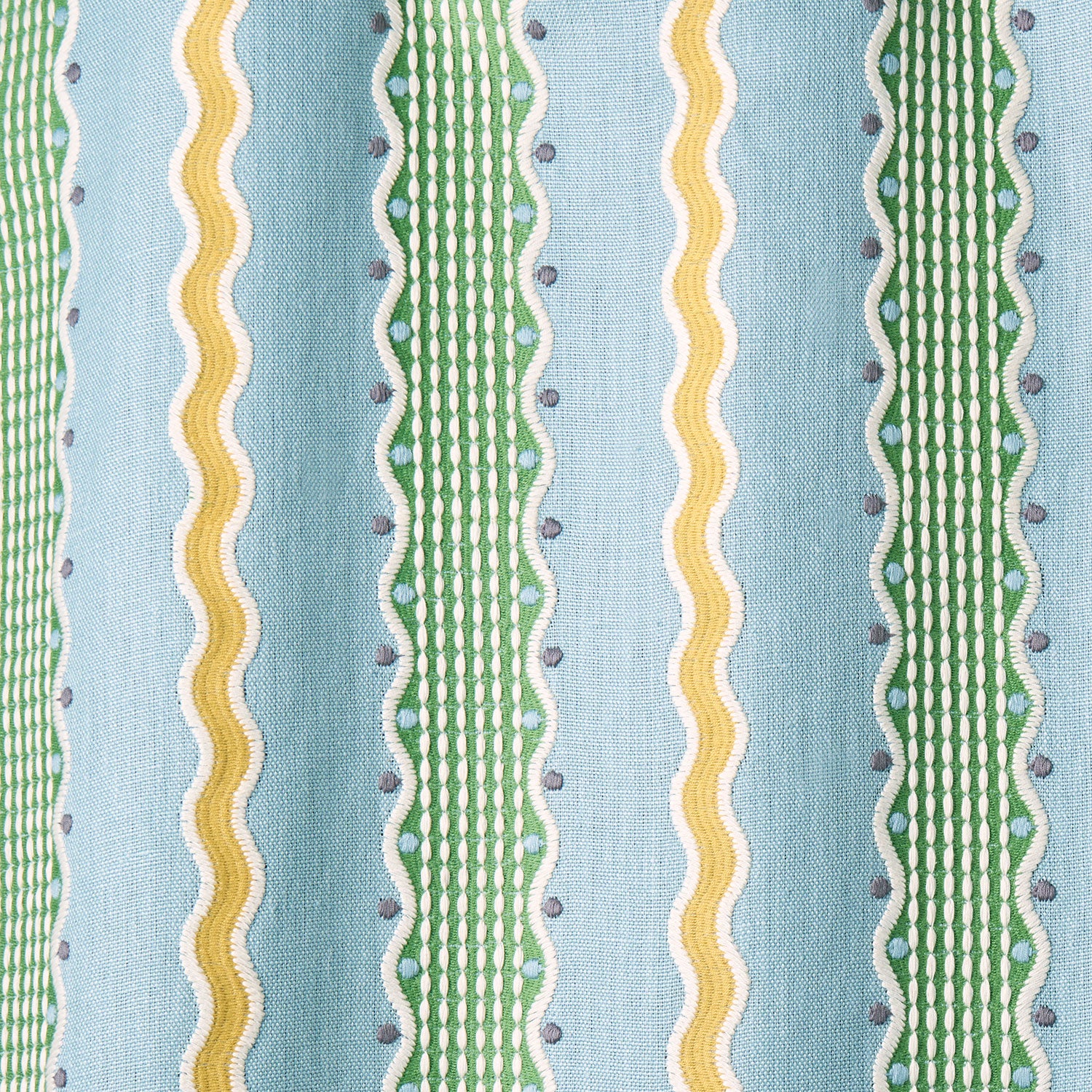 Embroidery fabric with green and yellow stripes on a blue background.
