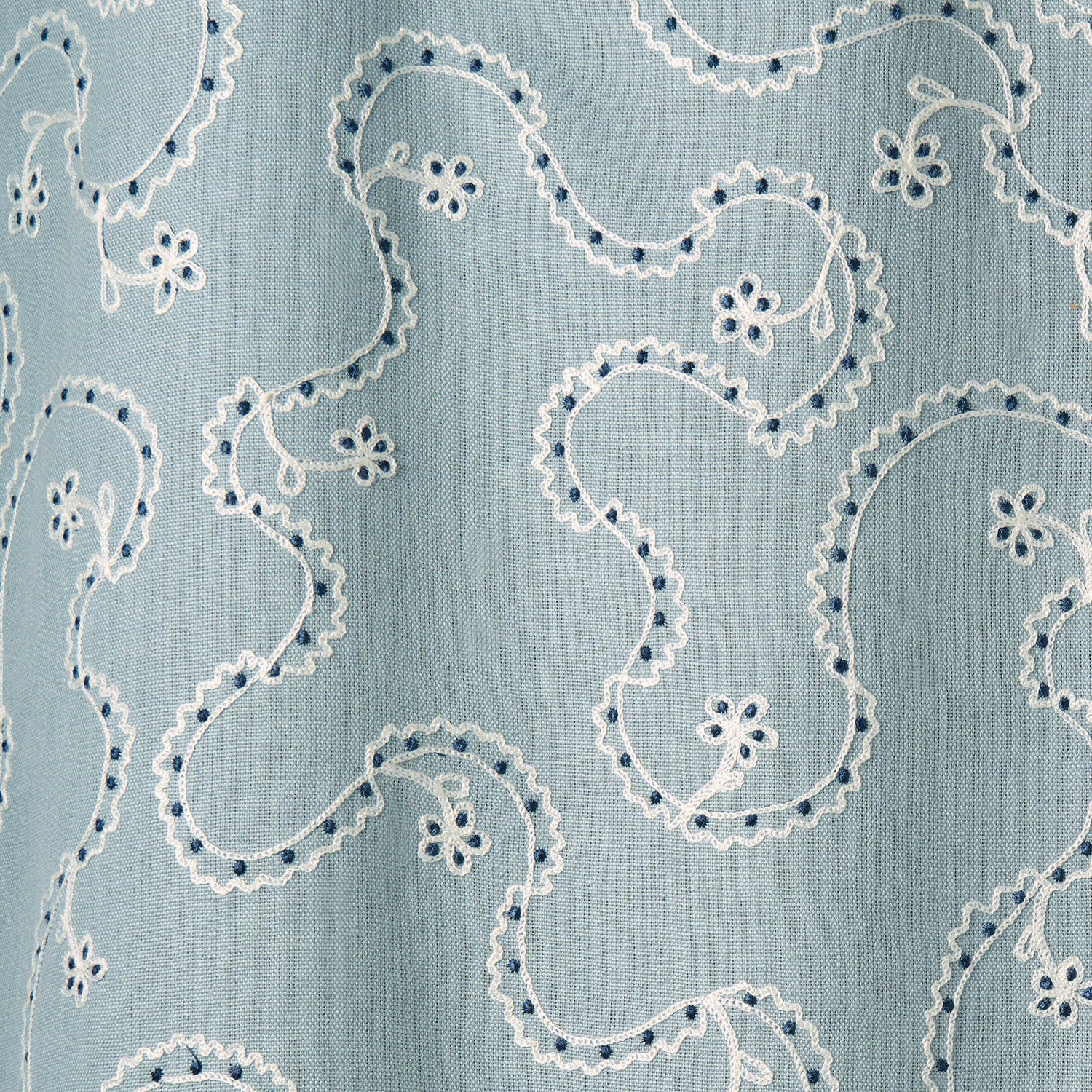 White embroidery pattern on a blue background.