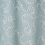 White embroidery pattern on a blue background.