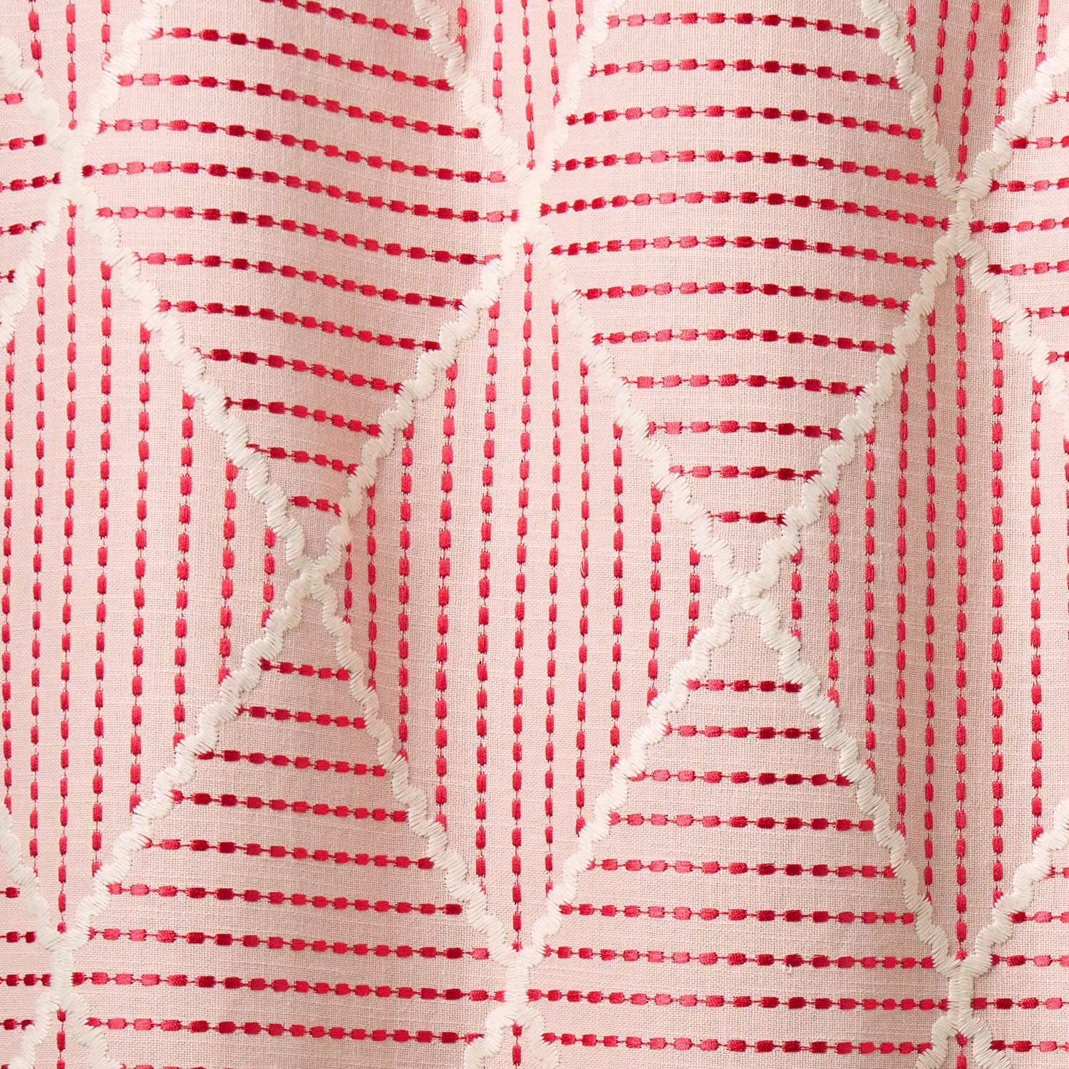 Geometric embroidery pattern with white lines on a pink background.