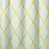 Geometric embroidery pattern with yellow and blue lines on a textured background.