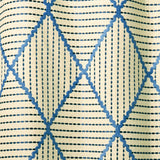 Geometric embroidery pattern with blue and beige lines on a textured background