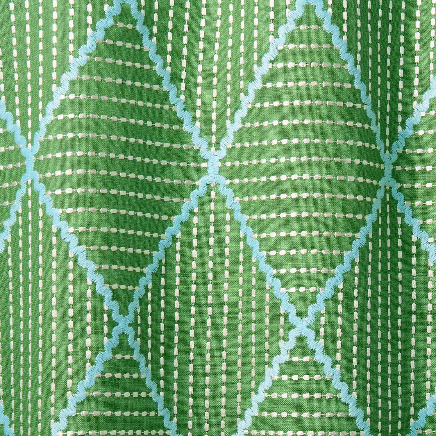 Geometric embroidery pattern with green and blue lines on a green background.