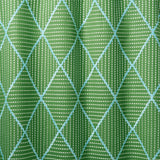 Geometric embroidery pattern with green and blue lines on a green background.
