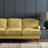 Sofa upholstered in a yellow and off-white woven fabric featuring a geometric pattern.