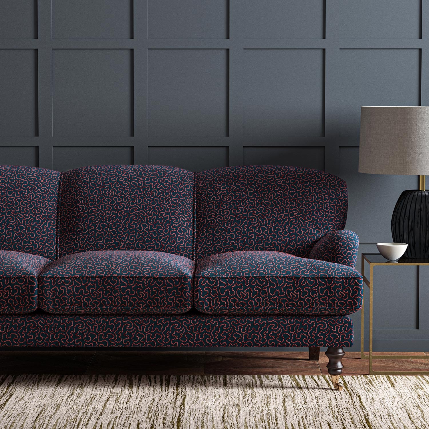 Sofa upholstered in a blue and red woven fabric featuring a wavy pattern.