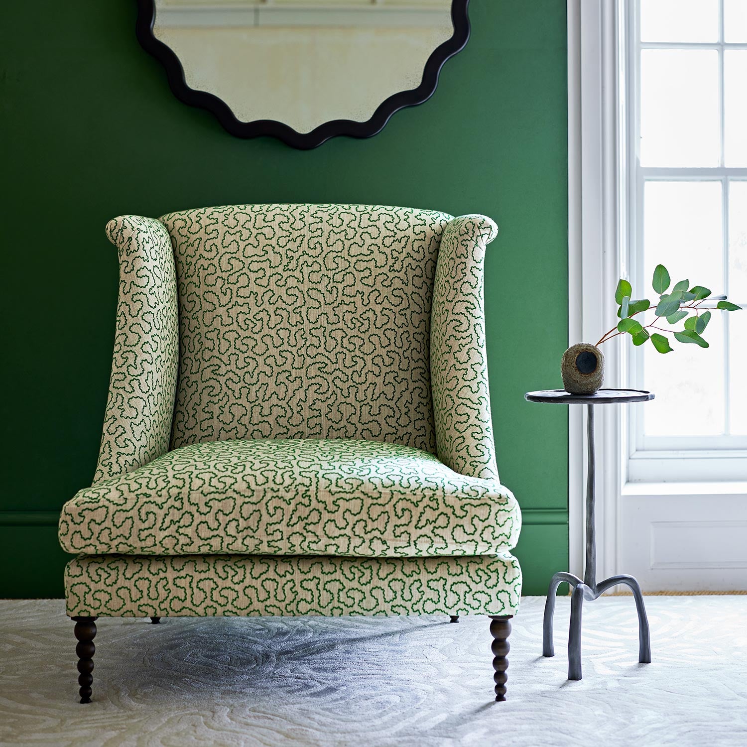 Chair upholstered in a green and off-white woven fabric featuring a wavy pattern.