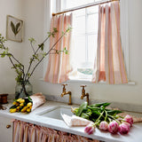 Linen curtains with a bold blocks of colour in this inviting stripe are softened with a painterly finish in pink, yellow and white