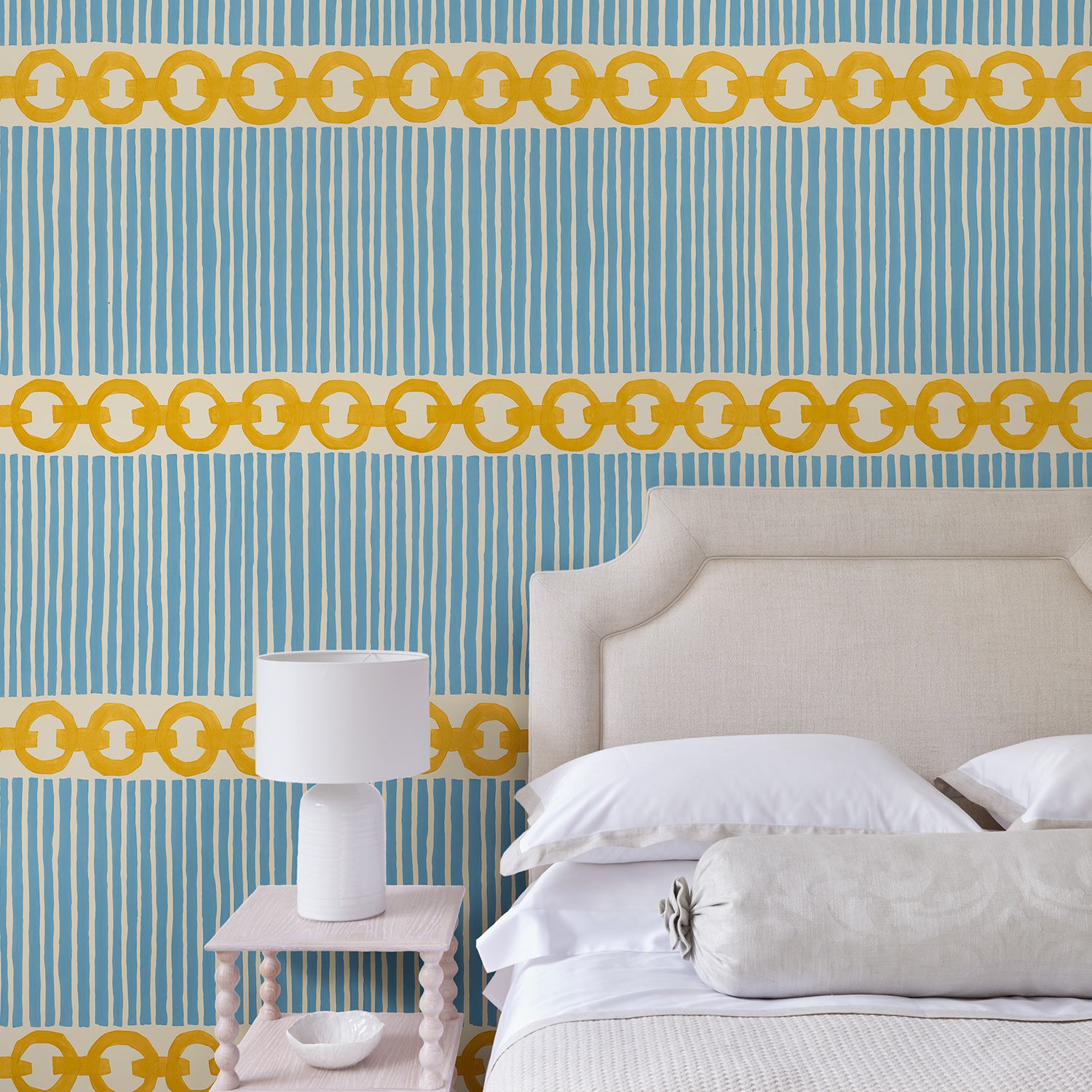 Bedroom with a chain-link wallpaper with different-sized blue and yellow stripes.
