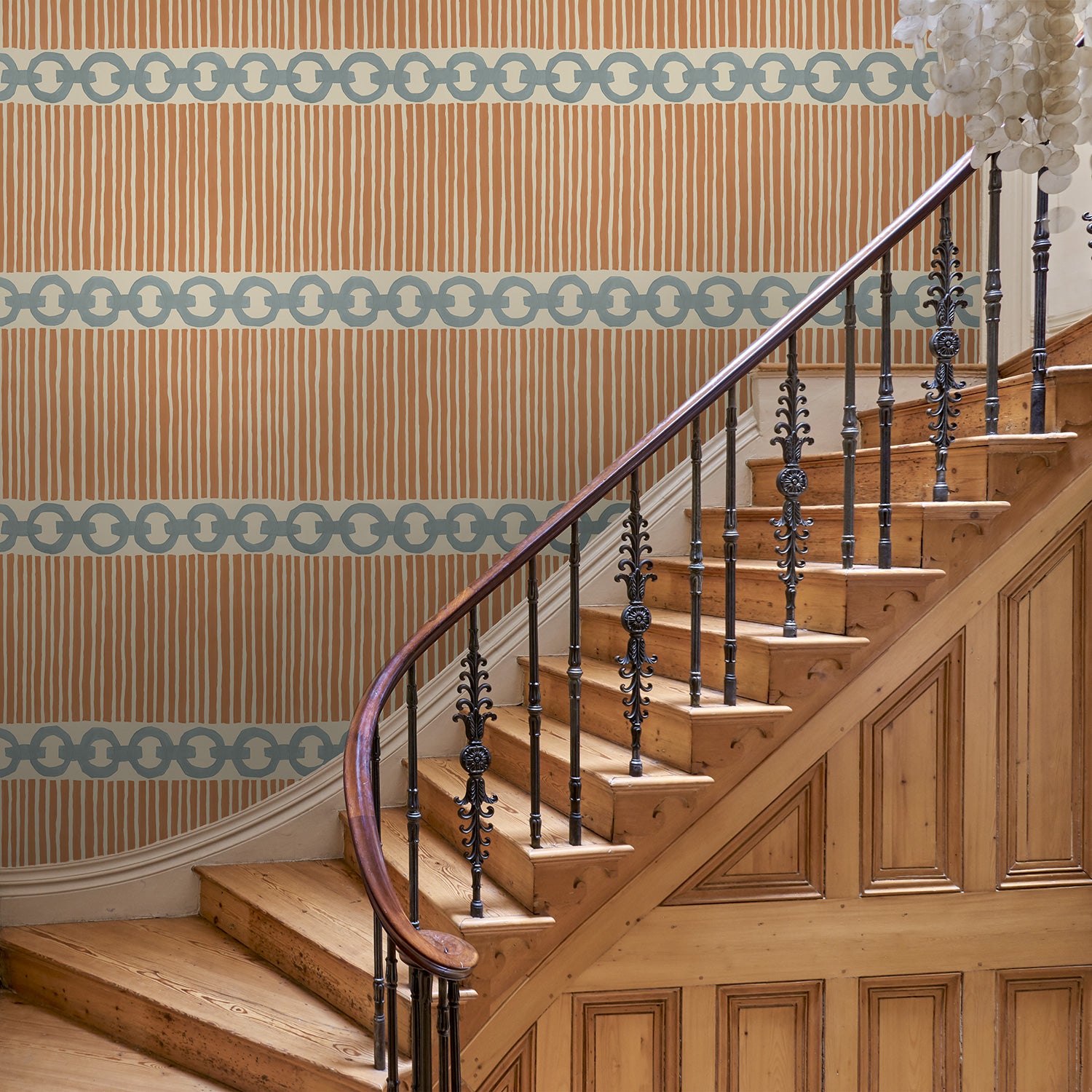 Hall with a chain-link wallpaper with different-sized blue and brown stripes.