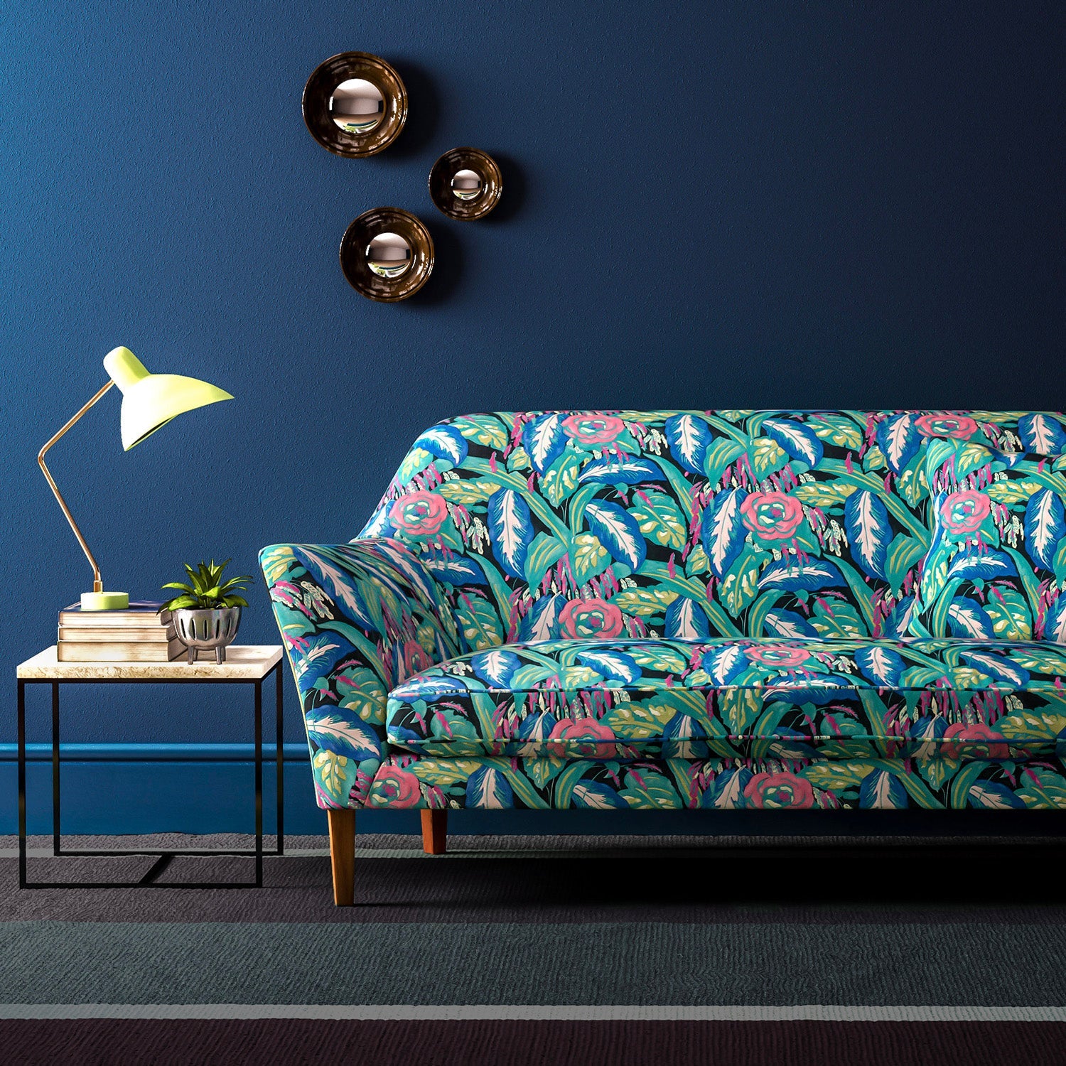 Sofa covered in a floral-style printed velvet fabric in blues and greens.
