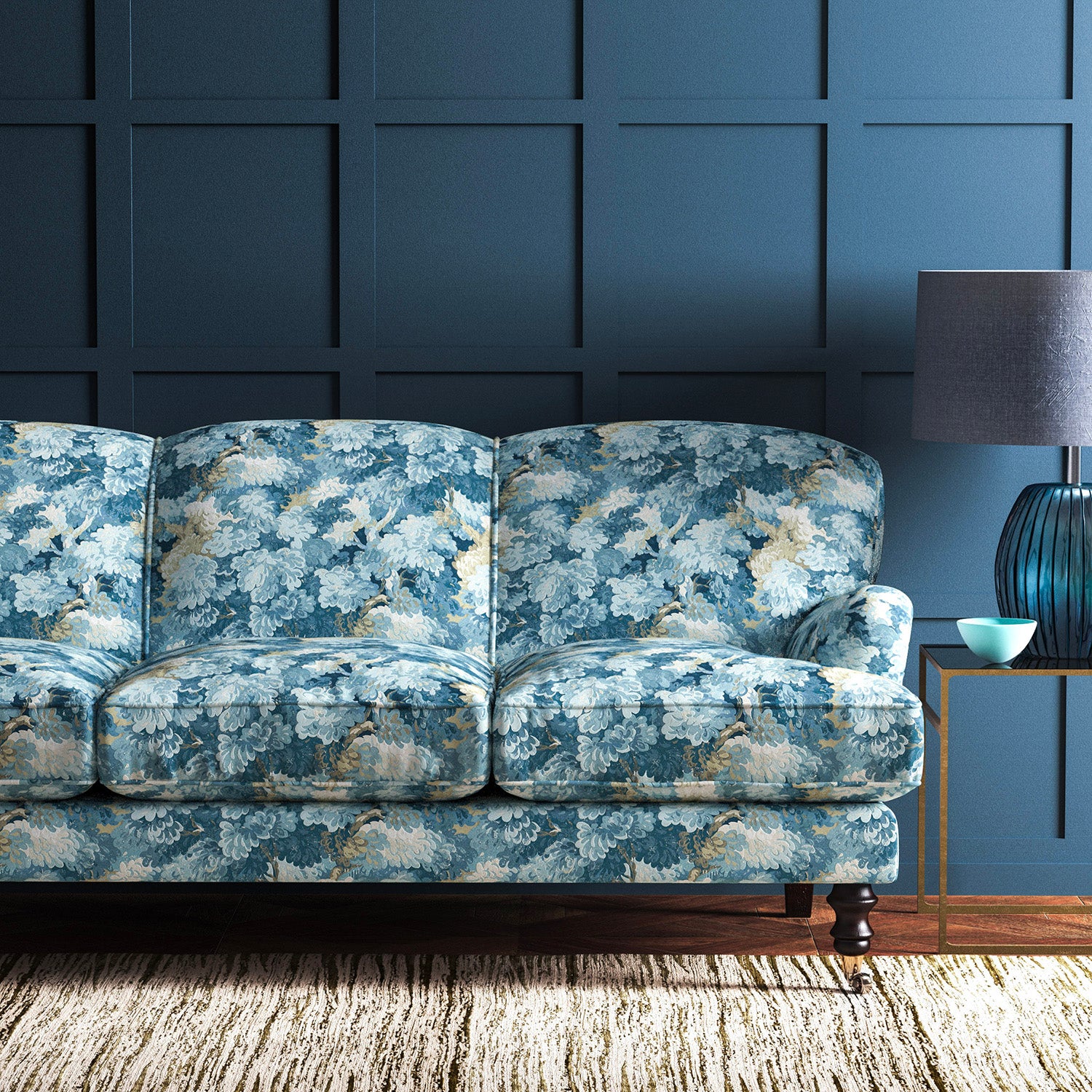 Sofa covered in a printed velvet fabric featuring a classic oak leaf design in Cornflower.