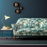 Sofa covered in a printed velvet fabric featuring a classic oak leaf design in teal.