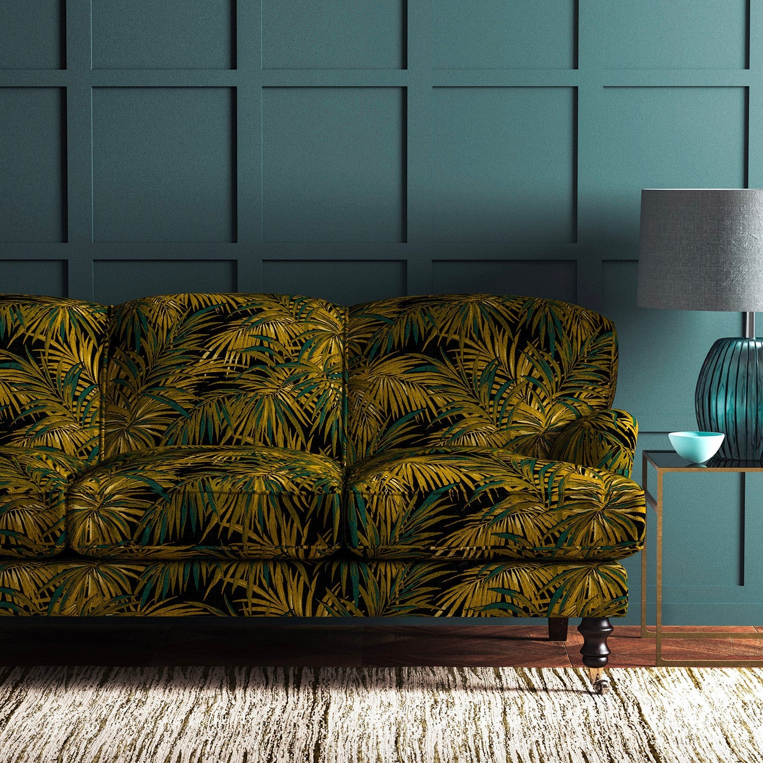 Sofa upholstered in green and gold printed velvet upholstery fabric with palm leaf design.