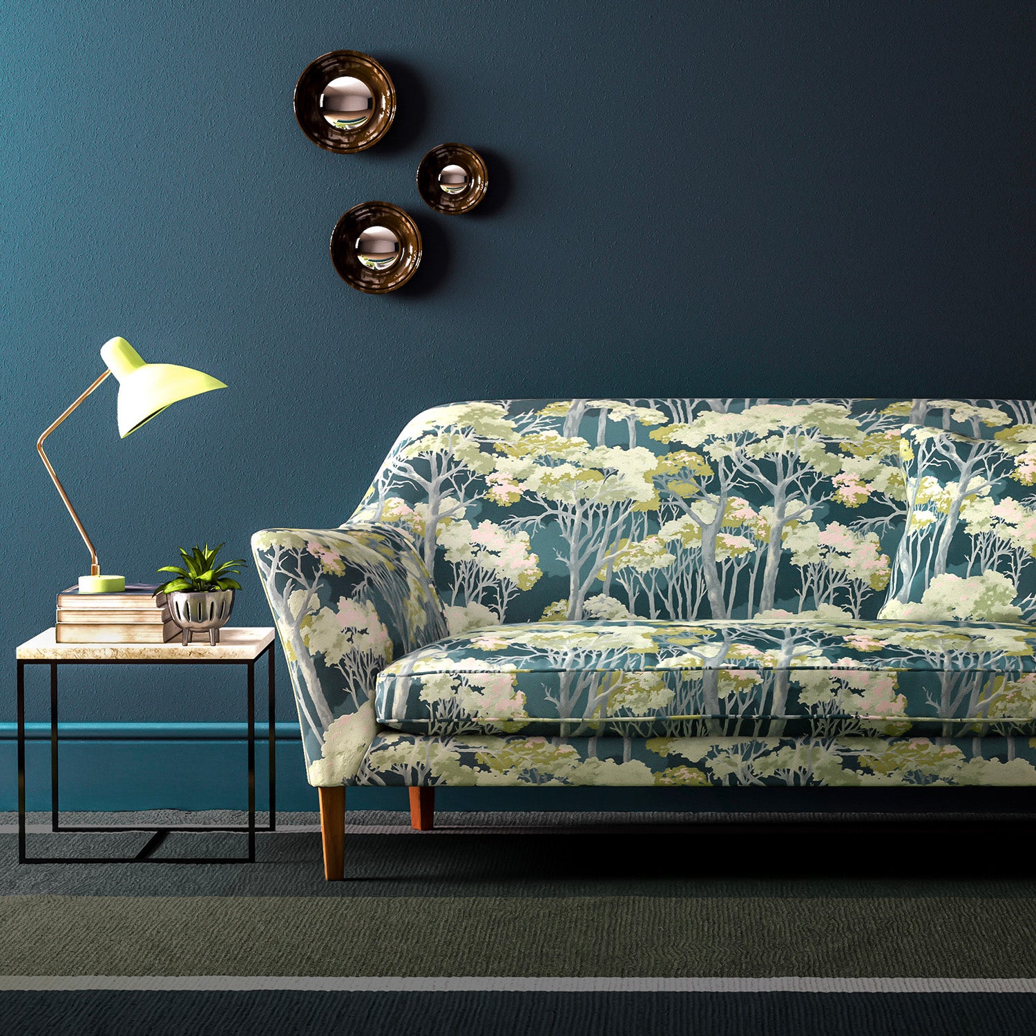 Sofa covered in a printed velvet upholstery fabric showcasing a blue/green Japanese tree design.