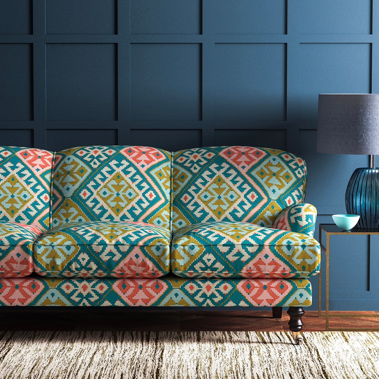 Sofa upholstered in a teal-pink velvet upholstery fabric with a kilim design with a stain resistant finish.