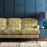Sofa covered in a printed velvet upholstery fabric featuring a fun, jazzy pattern in Ochre.
