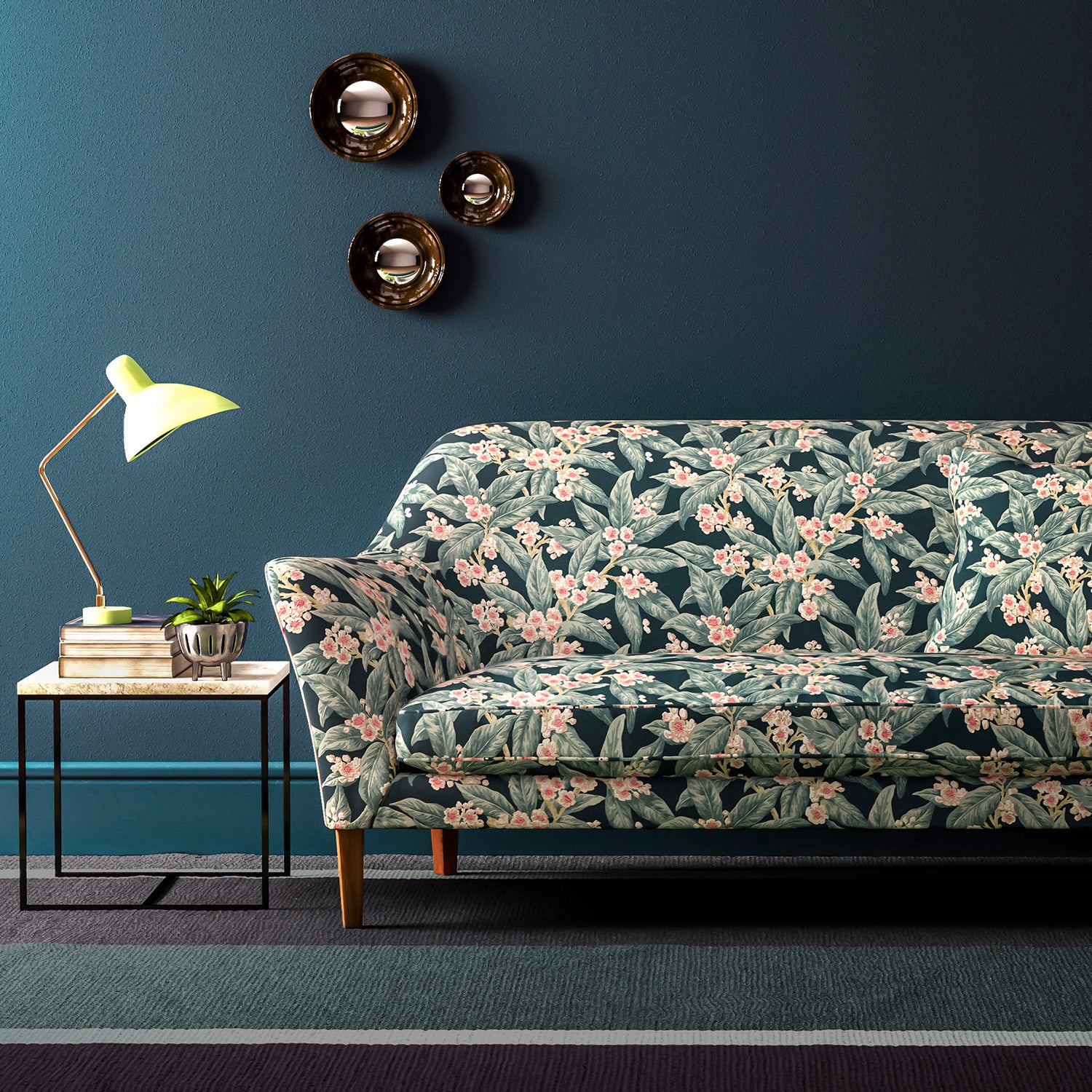 Sofa covered in a velvet upholstery fabric with a blue leaf and blossom design.