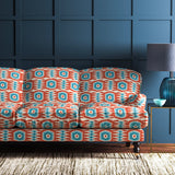 Velvet sofa upholstered in a orange and blue velvet upholstery fabric with abstract print and stain resistant finish