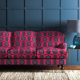 Sofa covered in a printed velvet upholstery fabric featuring a fun, jazzy pattern in Berry.