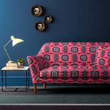 Sofa covered in a printed velvet upholstery fabric featuring a fun, jazzy pattern in Berry.