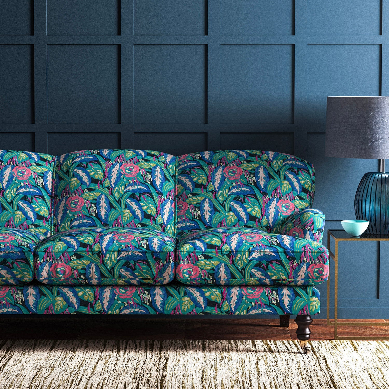 Sofa covered in a floral-style printed velvet fabric in blues and greens.
